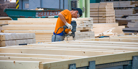 Dělník montuje část dřevostavby